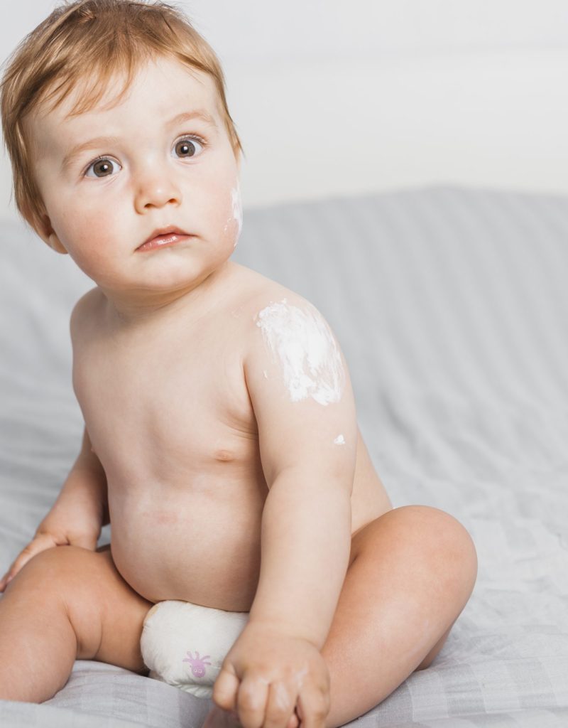 sitting-baby-spread-with-lotion